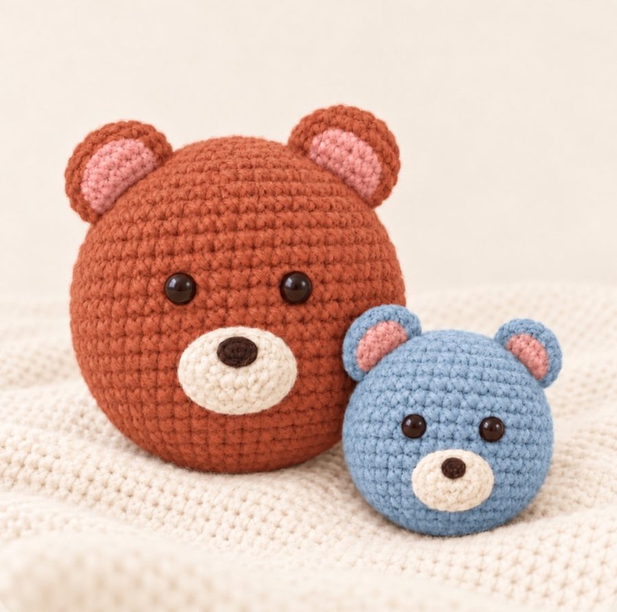A knitted terracotta parent bear and a baby-blue cub